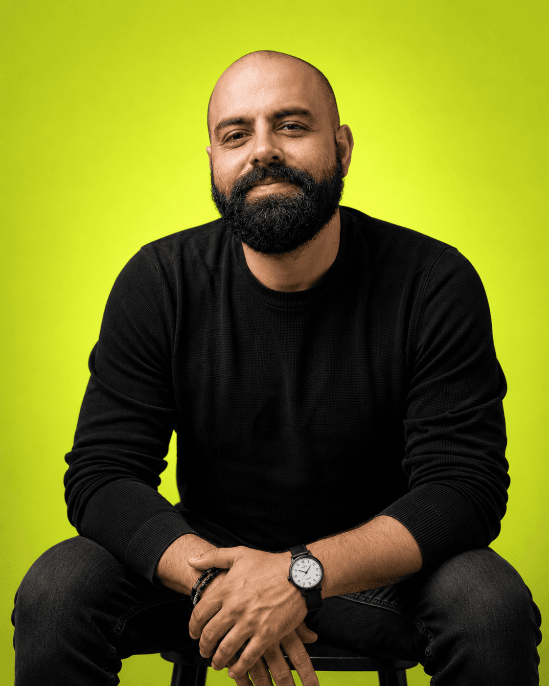 Salun Marvin, seated, arms resting on his knees, looking straight at the camera.